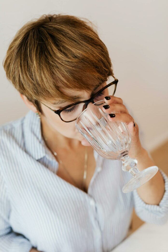 A woman drinking a glass of water, highlighting the issue of rising water bills in Leeds.